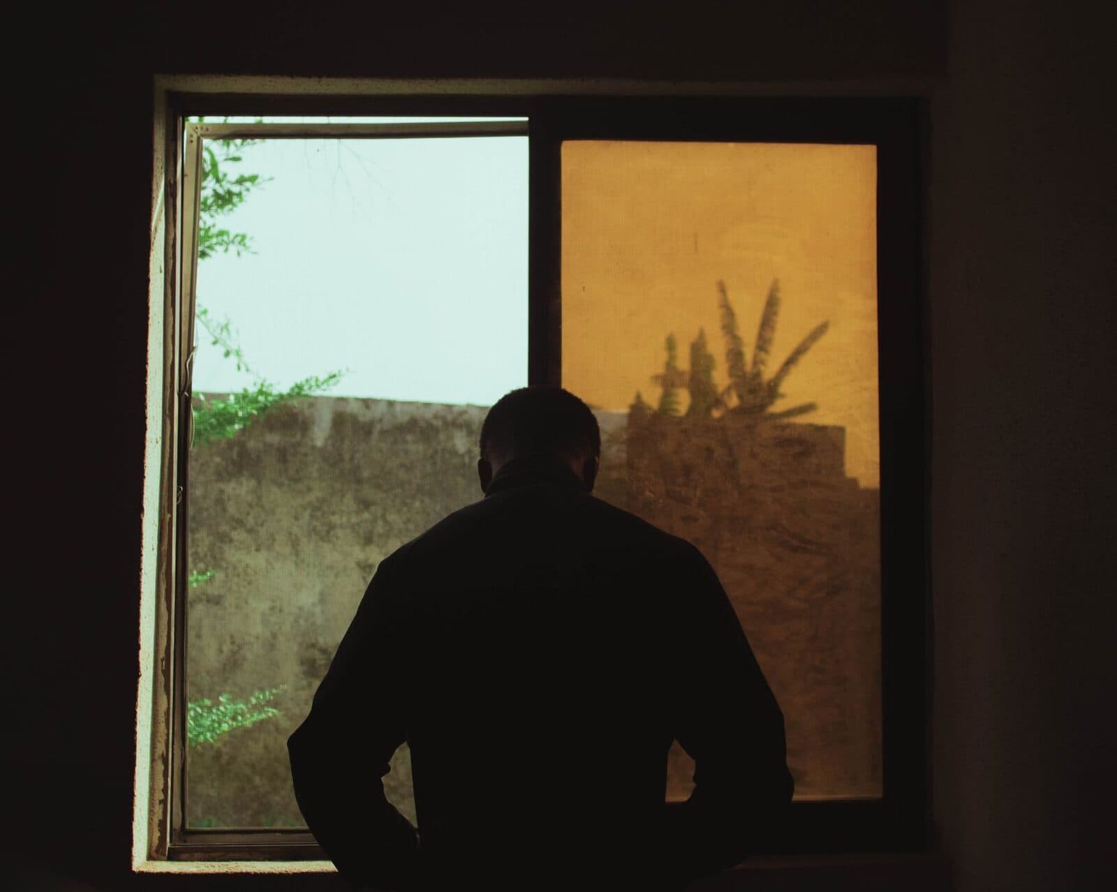 A person pausing at a window, taking a reflective moment